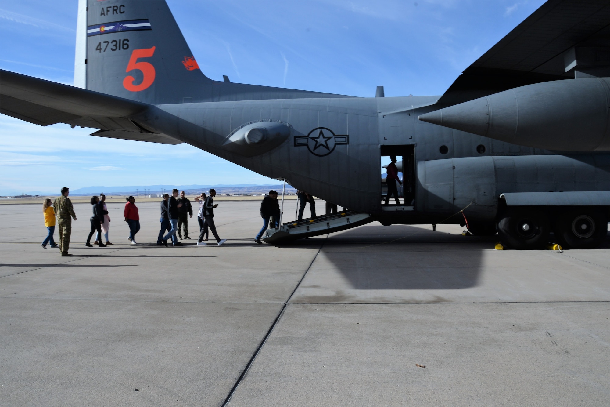 Students from Sierra High School, Colorado Springs, Colorado, board a parked Air Force Reserve C-130 Hercules aircraft during a tour of the 302nd Airlift Wing at Peterson Air Force Base, Colorado, Feb. 9, 2018.