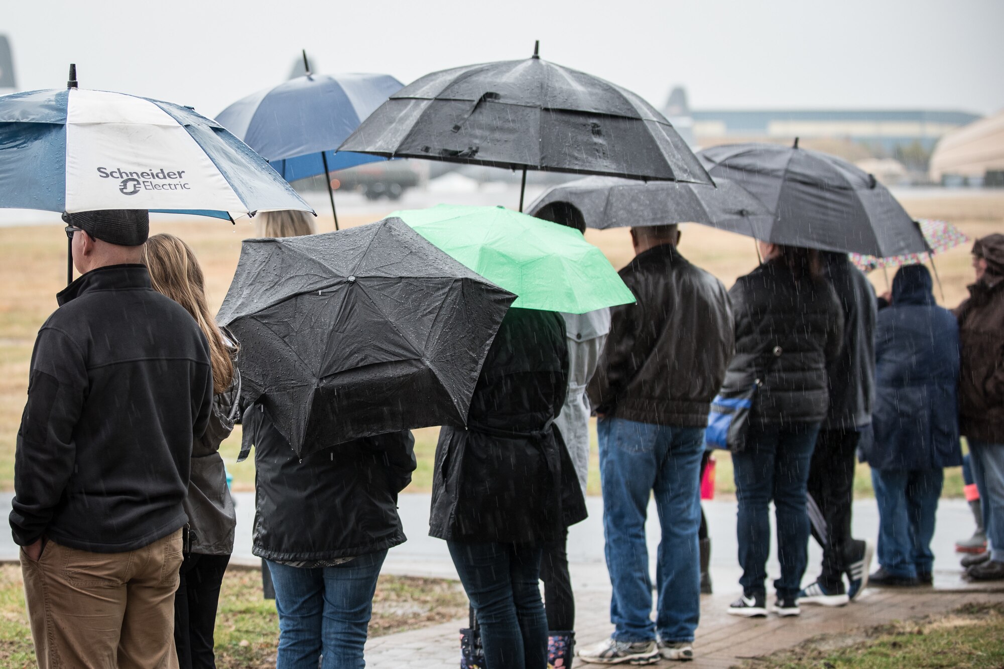 Friends and family of Kentucky Air National Guardsmen wait in the rain at the Kentucky Air National Guard Base in Louisville, Ky., Feb. 23, 2018, as their loved ones prepare to deploy to the Persian Gulf region.The Airmen will spend four months flying troops and cargo across the U.S. Central Command area of responsibility, which Includes Iraq, Afghanistan and northern Africa.