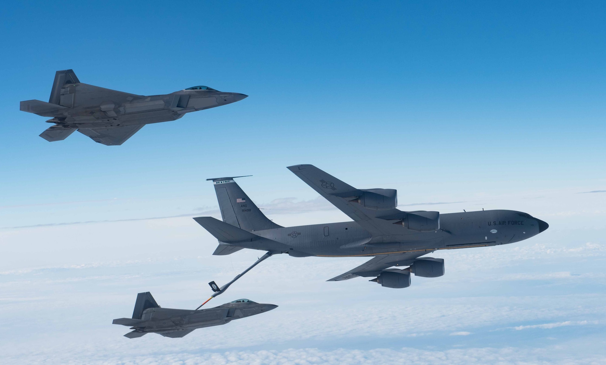 A KC-135 Stratotanker from the 101st Air Refueling Wing refuels F-22 Raptors from the 94th Fighter Squadron over the Atlantic Ocean, February 22, 2018.