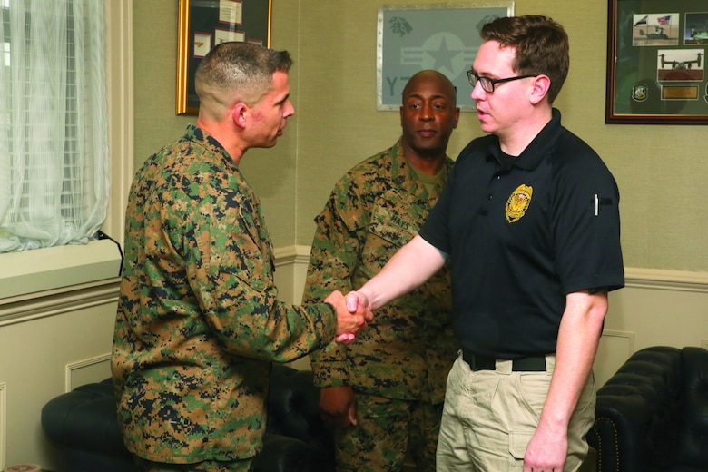 Police Officer Sean Sullivan is awarded a coin by Col. Timothy Miller aboard Marine Corps Air Station Beaufort, Feb. 20. Sullivan aided in the resuscitation of a recruit whose heart stopped aboard Marine Corps Recruit Depot Parris Island, Feb. 4. Sullivan is a police officer and Miller is the Commanding Officer of MCAS Beaufort.