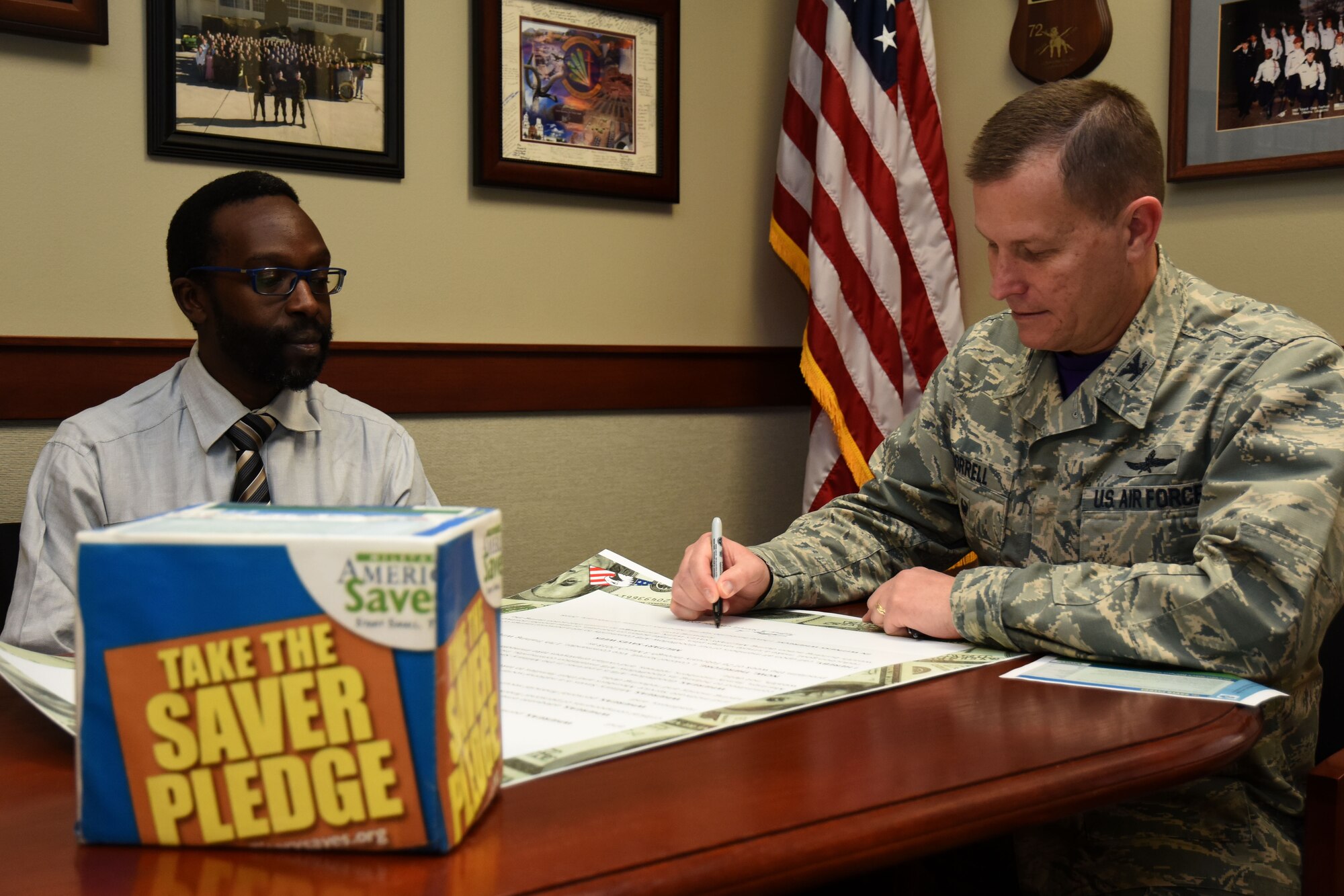 Financial Readiness manager, William Gathecha and U.S. Air Force Col. Jeffrey Sorrell, 17th Training Wing vice commander, sign a proclamation kicking off the Military Saves Week at the Norma Brown building on Goodfellow Air Force Base, Texas, on Feb. 23, 2018. The Airman and Family Readiness center has classes and seminars coordinated around setting up a savings plan for service members, civilians and their families Feb. 26 through March 3. (U.S. Air Force photo by Airman 1st Class Seraiah Hines/Released)