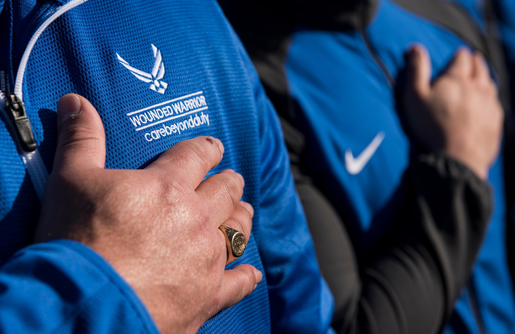Approximately 150 athletes hold their hands over their hearts during the singing of the national anthem during the 5th Annual Air Force Wounded Warrior Trials opening ceremony at the Warrior Fitness Center on Nellis Air Force Base, Nevada, Feb. 23, 2018. The trials are an adaptive sports event designed to promote the mental and physical well-being of seriously ill and injured military members and veterans. (U.S. Air Force photo by Senior Airman Kevin Tanenbaum)