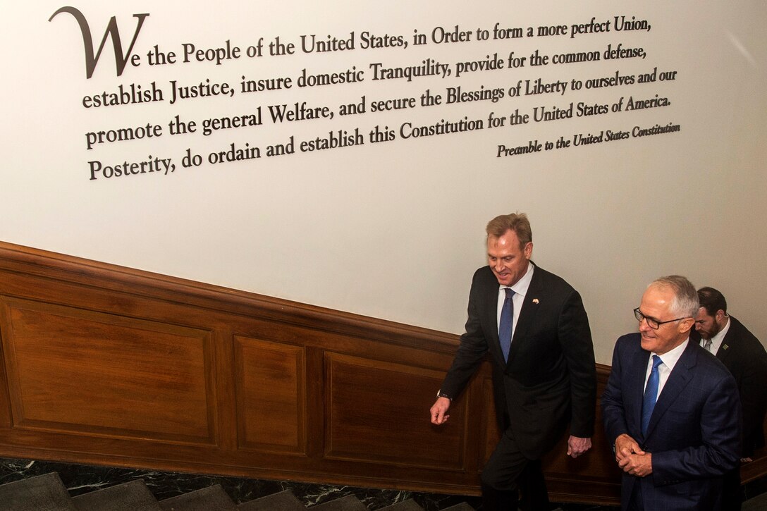 Two leaders walk up the stairs at the Pentagon.