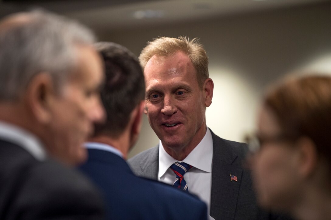 The deputy defense secretary speaks with a group of people.