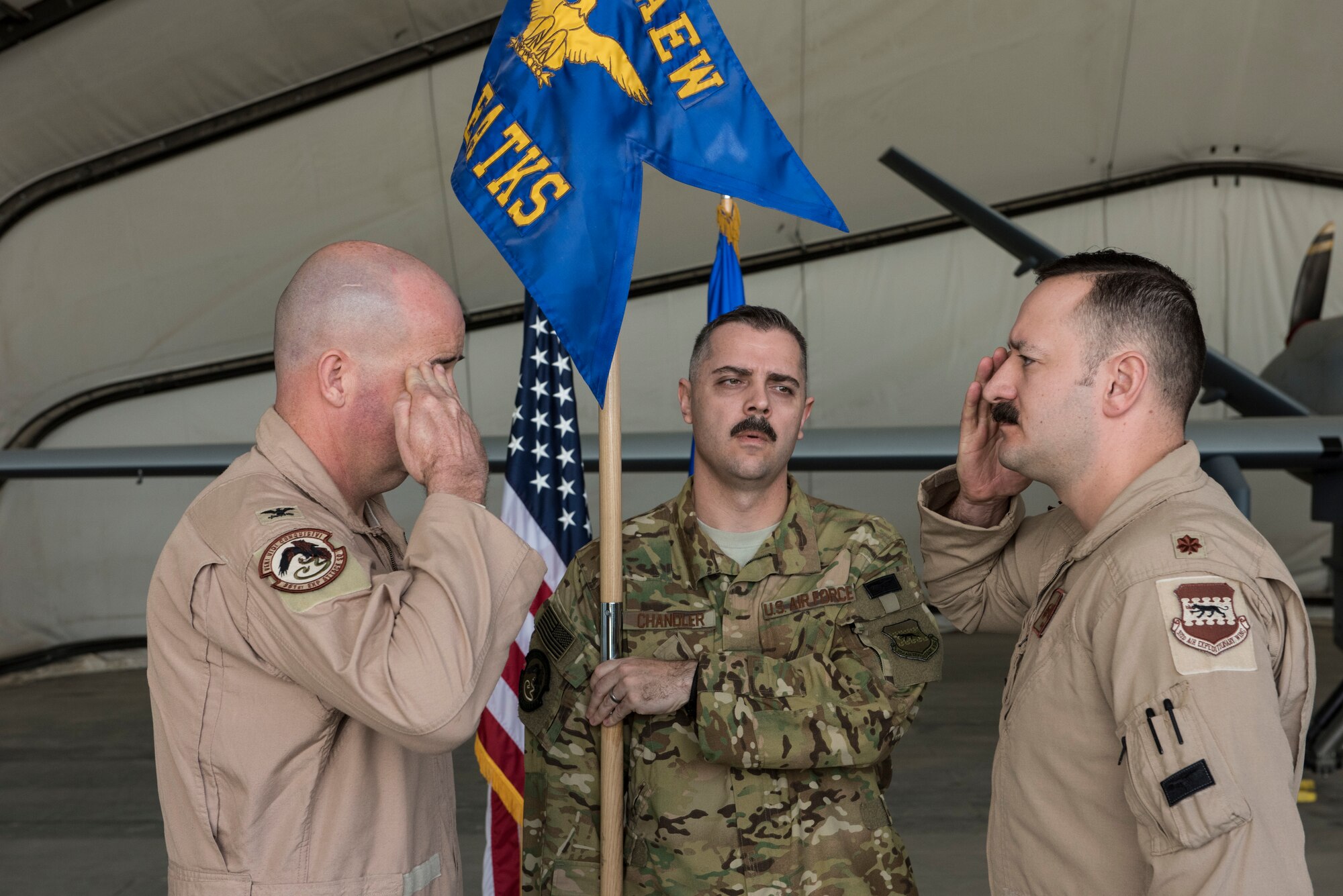 Col. William Marshall, commander of the 332d Expeditionary Operations Group, returns a salute to Maj. Robert McGowan after transferring command of the 361st Expeditionary Attack Squadron February 22, 2018, in Southwest Asia.  McGowan takes over command of the squadron from Lt. Douglas Olson. (U.S. Air Force photo by Staff Sgt. Joshua Kleinholz)