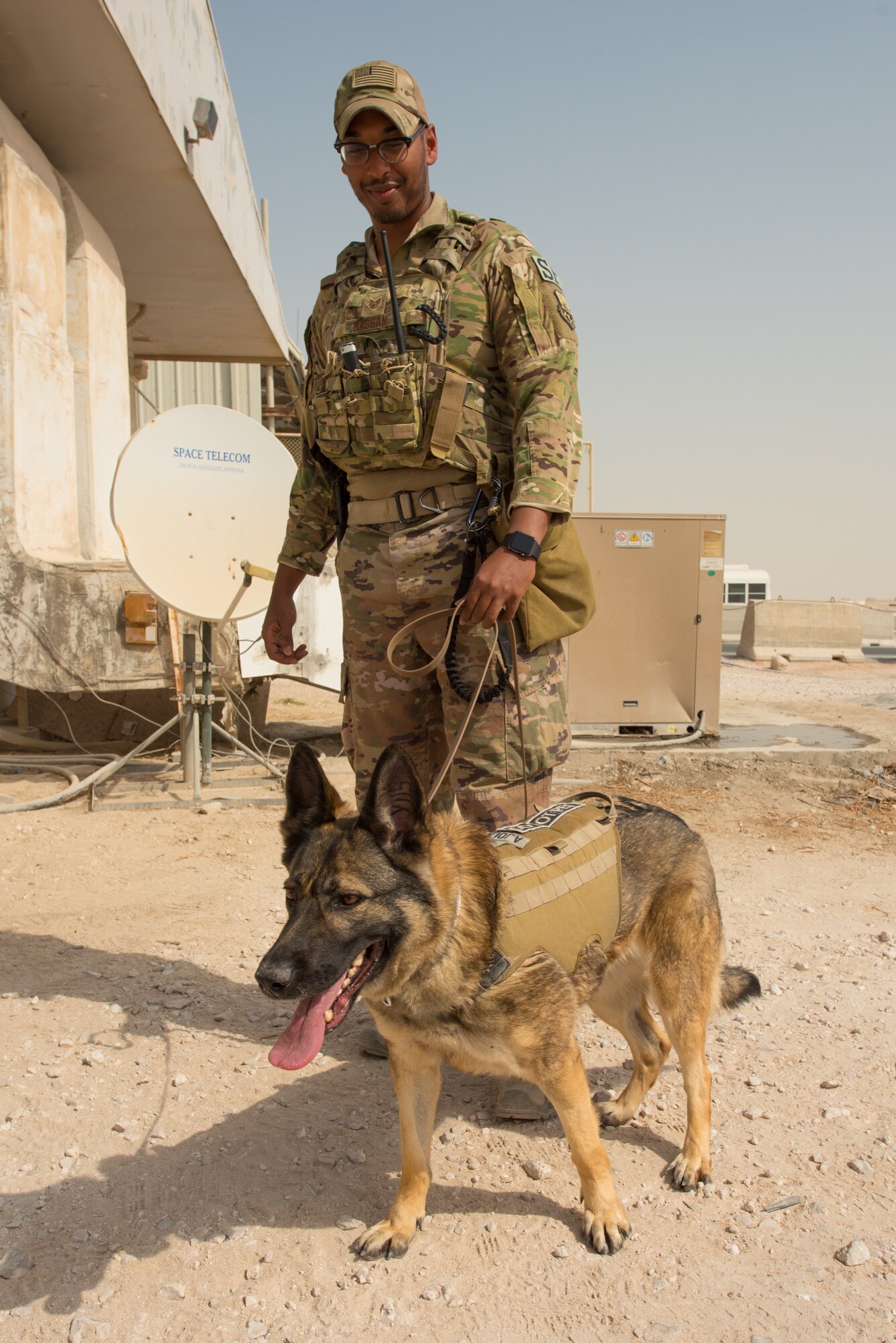 Staff Sgt. Jaafar Hassan, a dog handler for the 379th Expeditionary Security Forces Squadron, and his military working dog, Ajola, participate in a training scenario at Al Udeid Air Base, Qatar, Feb. 15, 2018. The exercise, a collaborative effort between security forces and the explosive ordnance disposal flight, simulated a vehicle borne improvised explosive device threat. (U.S. Air Force photo by Staff Sgt. Joshua Horton)
