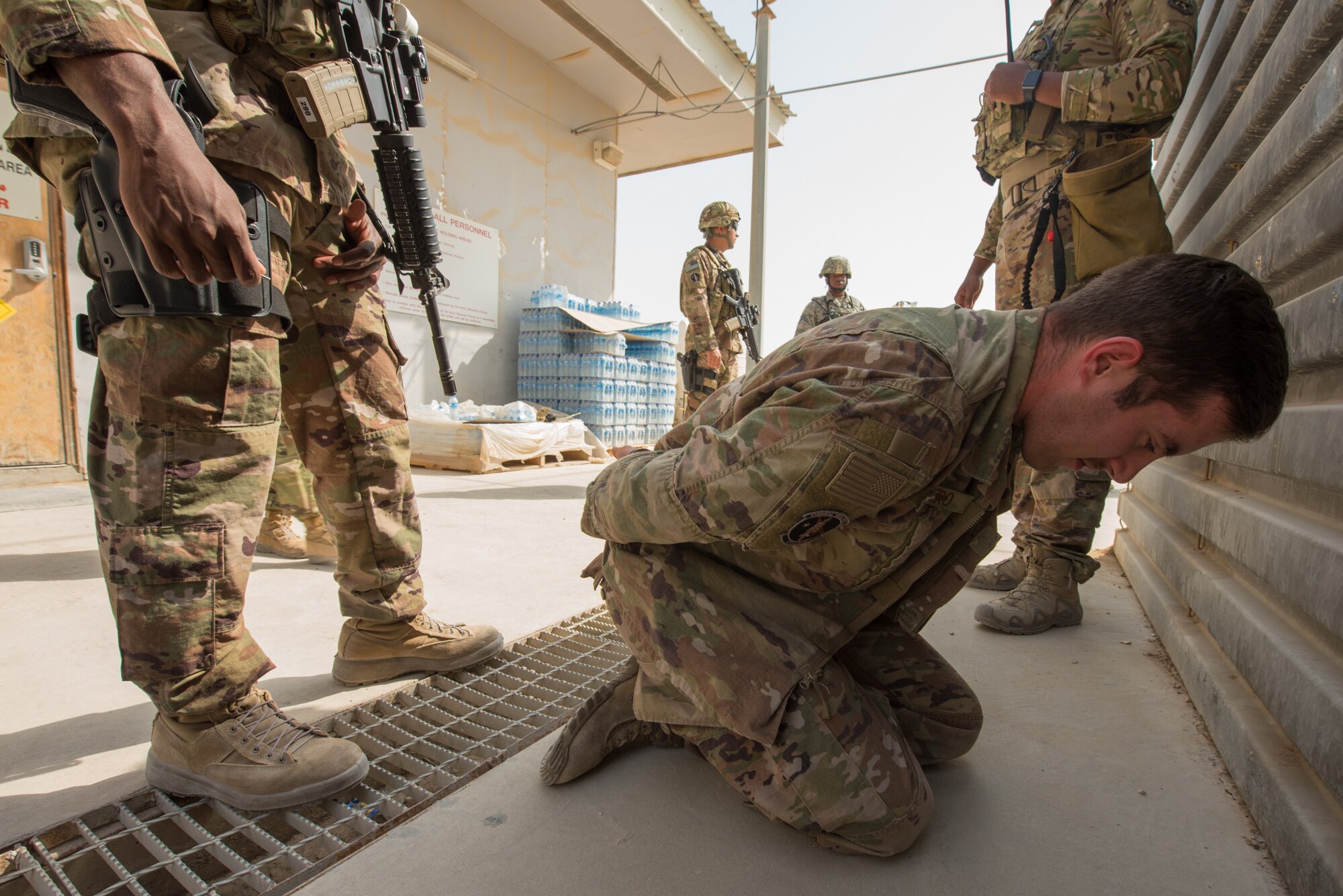 Staff Sgt. Travis Fiero (right), a dog handler for the 379th Expeditionary Security Force Squadron, simulates an enemy being held captive during a training scenario at Al Udeid Air Base, Qatar, Feb. 15, 2018. The exercise, a collaborative effort between security forces and the explosive ordnance disposal flight, simulated a vehicle borne improvised explosive device threat. (U.S. Air Force photo by Staff Sgt. Joshua Horton)