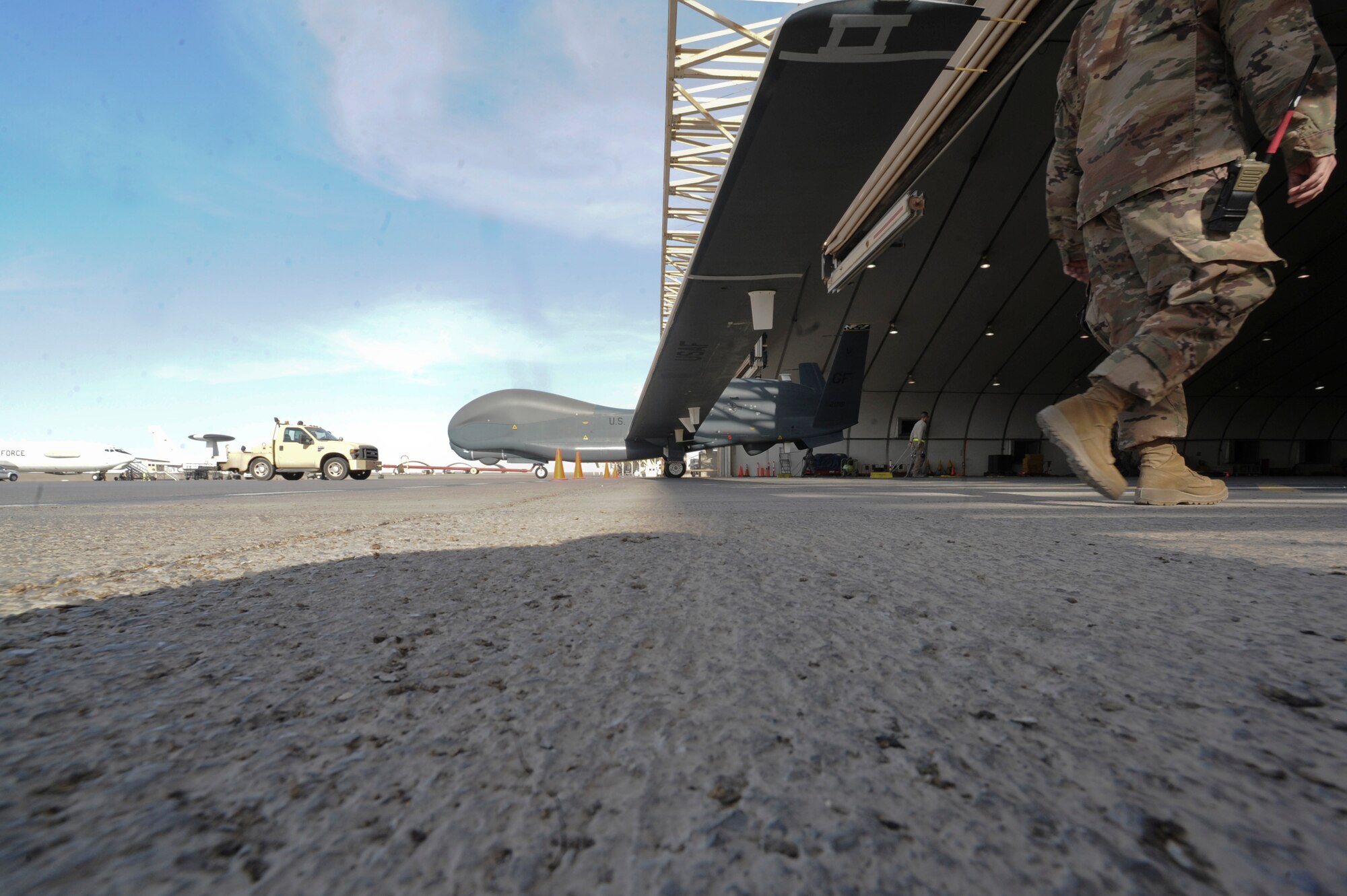 An Airman from the 99th Expeditionary Reconnaissance Squadron tows an U.S. Air Force RQ-4 Global Hawk into a hanger on Al Dhafra Air Base, United Arab Emirates Feb. 13, 2018. The Global Hawk's mission is to provide a broad spectrum of ISR collection capability to support joint combatant forces in worldwide peacetime, contingency and wartime operations. (U.S. Air Force photo by Airman 1st Class D. Blake Browning)