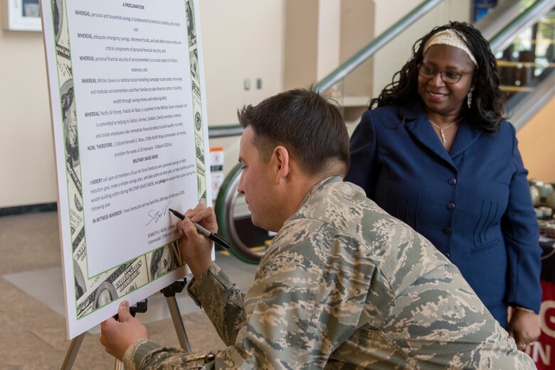 Col. Sergio Vega, 374th Airlift Wing vice commander, signs the proclamation officially beginning the Military Saves campaign at Yokota Air Base, Japan, Feb. 26, 2018.