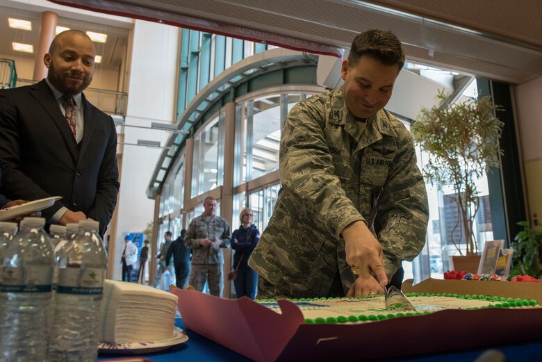 Col. Sergio Vega, 374th Airlift Wing vice commander, slices a cake to commemorate the beginning of the Military Saves campaign at Yokota Air Base, Japan, Feb. 26, 2018.