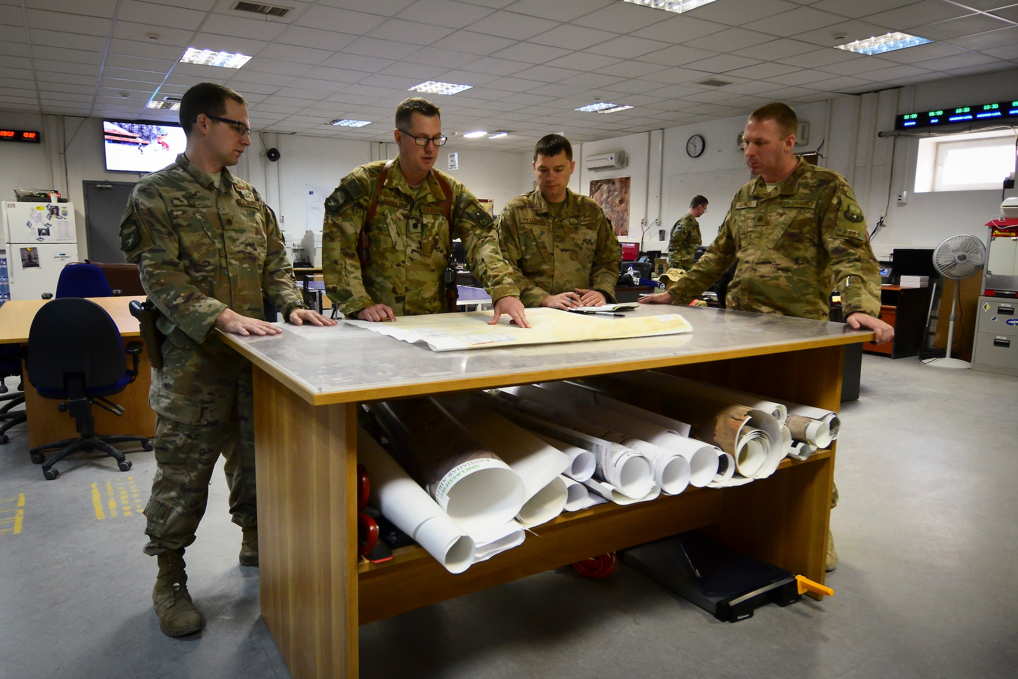 U.S. Air Force Maj. Jon Roe, Lt. Col. Patrick Schuldt, Master Sgt. Kevin Peterson and Maj. Geoffrey Border (left to right), leaders assigned to the 451st Expeditionary Operations Support Squadron, review plans for the continual build-up at Kandahar Airfield, Afghanistan Feb. 22, 2018.