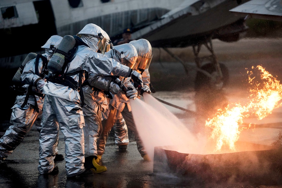 U.S. Marines and Thai navy firefighters work together to extinguish an aircraft fire simulating a crash during aircraft extraction training.