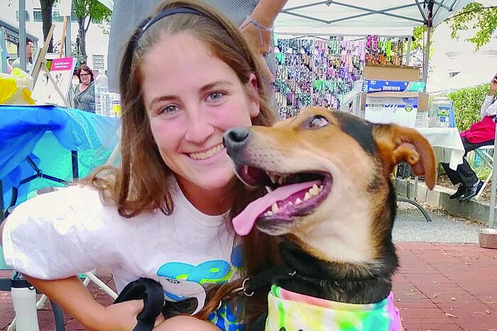 A Marine smiles as she poses for a picture with a cute dog.