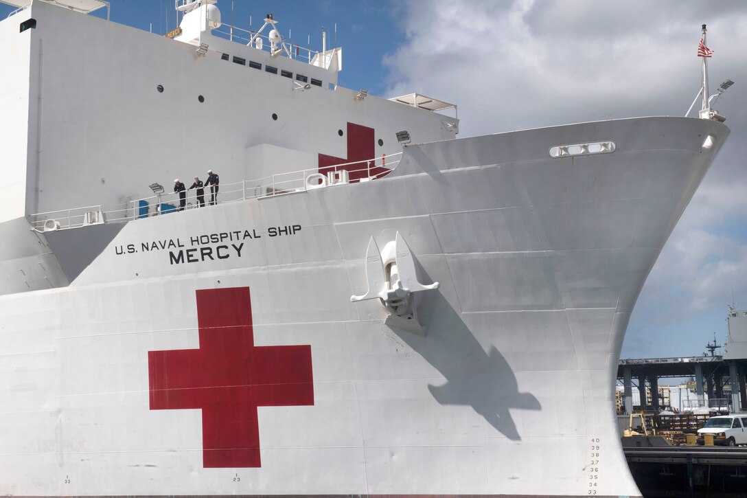 Sailors aboard the Hospital ship USNS Mercy wave good-bye to family members and friends as it prepares to depart Naval Base San Diego.