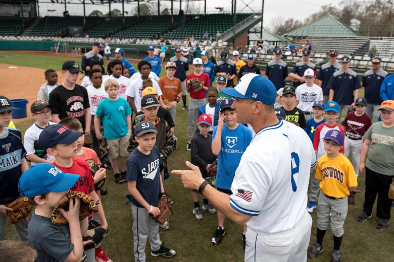 Mike Kazlausky, Air Force Academy baseball head coach, talks to the more than 30 boys and girls participating in the kids' baseball clinic taught by coaches and players from the Air Force and Naval Academy baseball teams Feb. 24, 2018, at Grainger Stadium in Kinston, North Carolina. The coaches and players taught the kids a variety of baseball skills to include, how to throw a baseball, how to field ground balls and line drives, and how to run the bases. (U.S. Air Force photo by Tech. Sgt. David W. Carbajal)