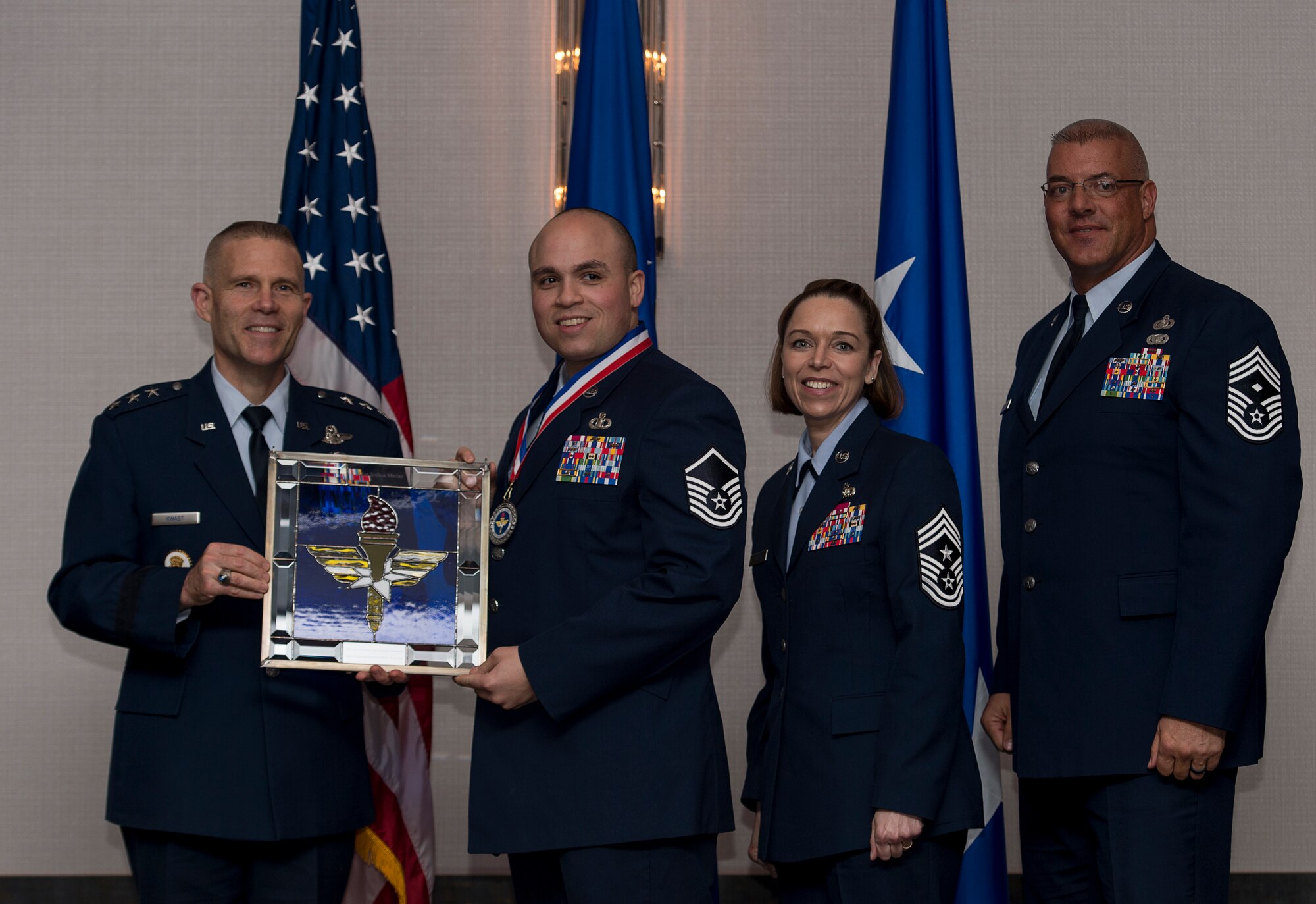 U.S. Air Force Master Sgt. Joshua Matias, Tower Chief Controller assigned to the 14th Operations Support Squadron at Columbus Air Force Base, Miss., receives the Air Education and Training Command Senior Non-Commissioned Officer of the Year Award from Lt. Gen. Steve Kwast, Commander of AETC during the AETC 12 Outstanding Airmen of the Year Awards banquet, Feb. 22, 2018, in Orlando, Fla. Matias acted as a Forward Deployed Superintendent, leading 107 Airmen through eight major combat operations, freeing 500,000 civilians in Mosul, pioneered first-ever Close Air Support targeting system into F-22 Raptors, syncing four agencies and three domains with emerging technology; and acted as a Boys and Girls Club Board of Directors member, managing a $786,000 budget and mentoring 240 children. (U.S. Air Force photo by Staff Sgt. Kenneth W. Norman)