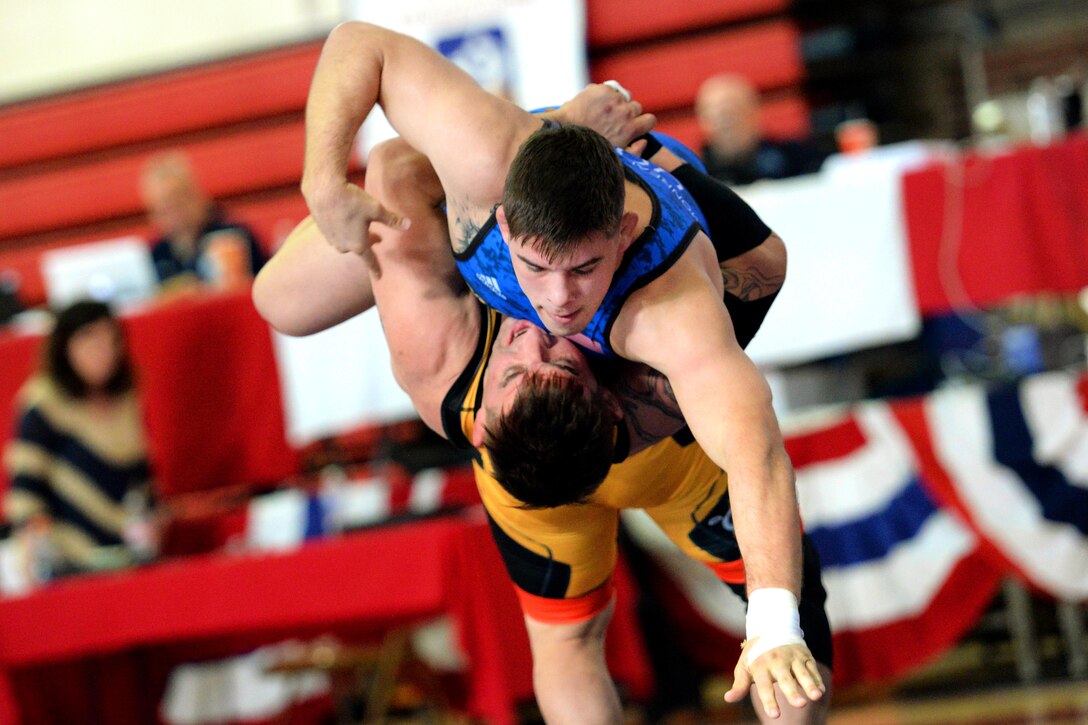 Army Sgt. Courtney Meyers, bottom, throws Marine Corps Cpl. Vaughn Monreal-Berner in the 87 kg weight class during the 2018 Armed Forces Wrestling Championship Greco-Roman competition.
