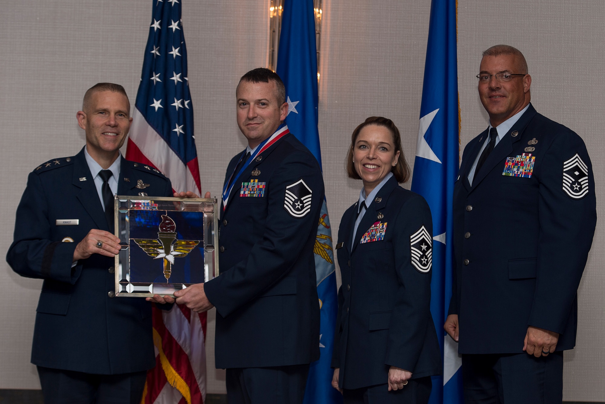 U.S. Air Force Master Sgt. Jason M. Bernich, Superintendent of the base Honor Guard at Keesler Air Force Base, Miss., receives the Chief Master Sergeant of the Air Force Base Honor Guard Program Manager of the Year Award from Lt. Gen. Steve Kwast, Commander of Air Education and Training Command, during the AETC 12 Outstanding Airmen of the Year Awards banquet Feb. 22, 2018 in Orlando, Fla. Bernich shaped AETC’s largest Honor Guard area of responsibility, managing 740 honors, 9,500 man-hours and a $70,000 budget, codified funeral requests and liaised with 674 directors and 422 funeral homes, reducing processing time by 101 hours annually, as well as restructured a uniform exchange, outfitting 45 Civil Air Patrol and 122 Junior Reserve Officers' Training Corps cadets. (U.S. Air Force photo by Staff Sgt. Kenneth W. Norman)