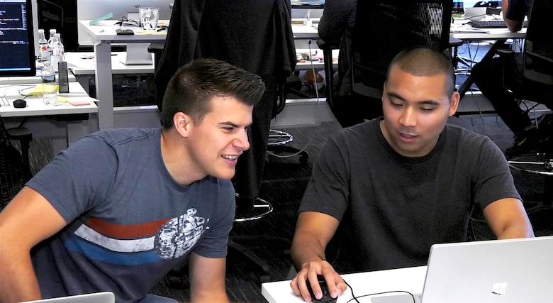 Capt. Bryon Kroger, left, and 1st Lt. Carlo Viray, right, review combat applications in Cambridge, Massachusetts, Aug. 13, 2017. The officers, who are part of the Air Force’s Air Operations Center Pathfinder acquisition program run out of Hanscom Air Force Base, Massachusetts, work with coders in an open workspace environment with civilians who train them on the techniques used by Silicon Valley’s best software programmers. (U.S. Air Force photo by Rick Berry)