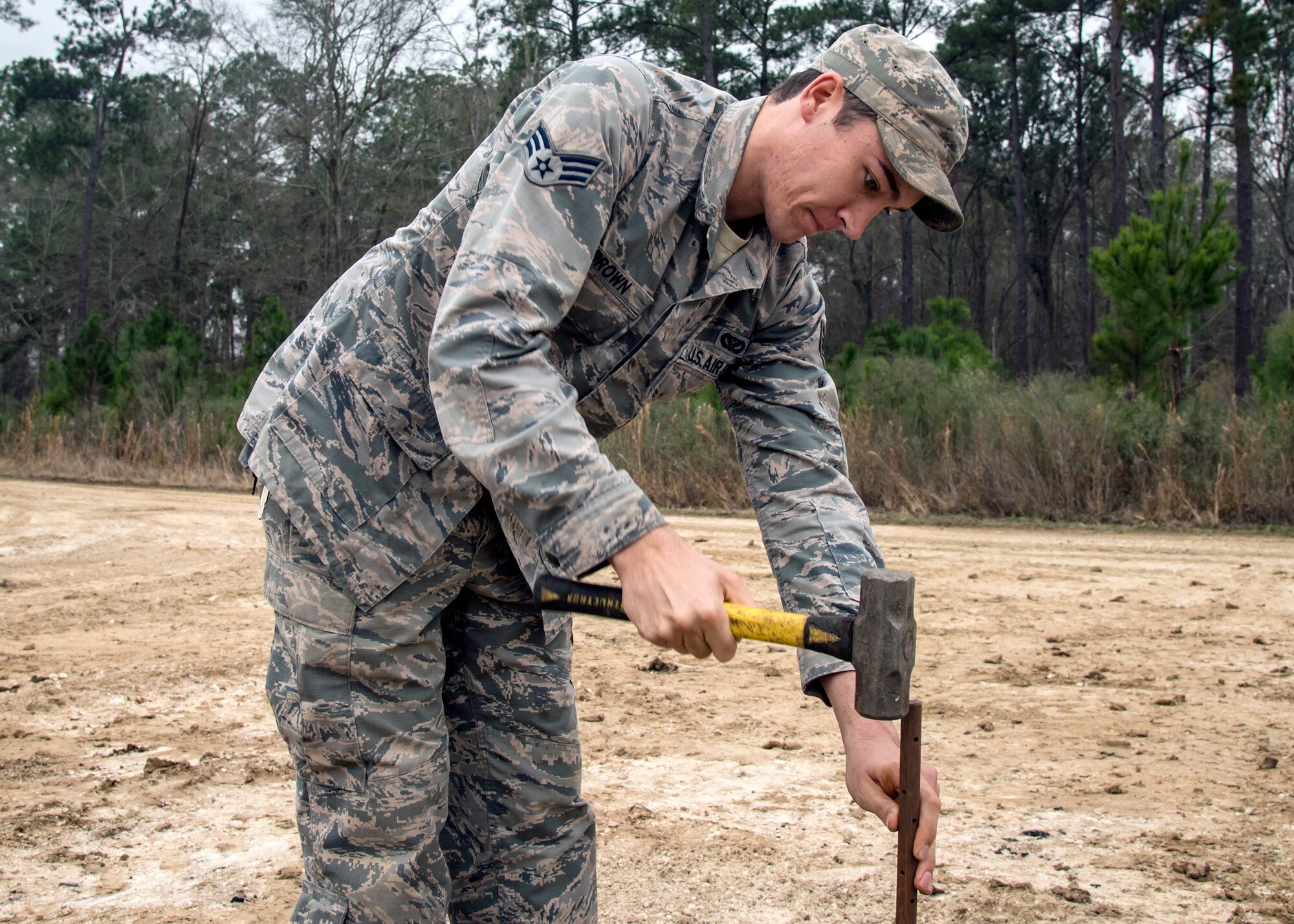 Senior Airman Davon Brown, 23d Civil Engineer Squadron pavements and equipment specialist, hammers a post into the ground, Feb. 15, 2018, at Moody Air Force Base, Ga.  Airmen from the 23d CES participated in a Prime Base Engineer Emergency Force training day to prepare for some of the wartime tasks they could encounter while in a deployed environment. (U.S. Air Force photo by Airman Eugene Oliver)