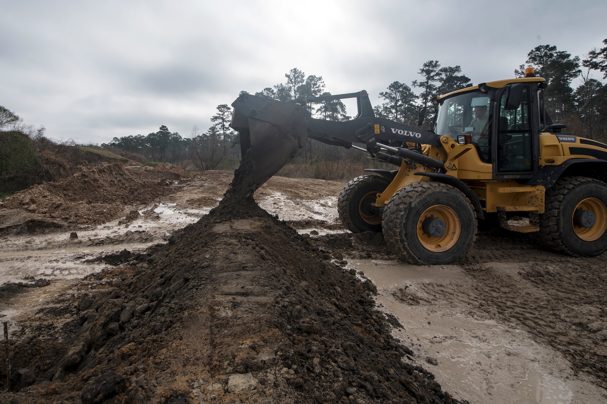 A loader drops dirt on a bern, Feb. 15, 2018, at Moody Air Force Base, Ga. Airmen from the 23d CES participated in a Prime Base Engineer Emergency Force training day to prepare for some of the wartime tasks they could encounter while in a deployed environment. (U.S. Air Force photo by Airman Eugene Oliver)