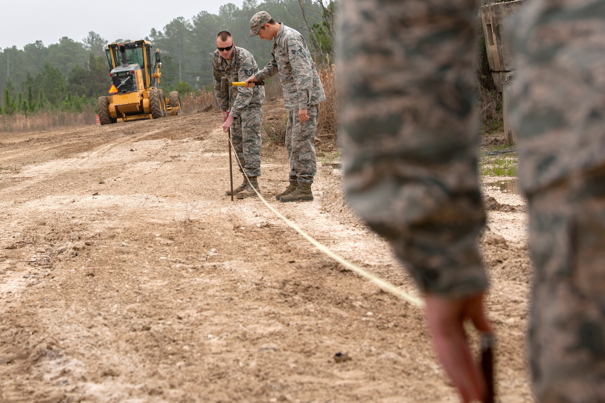 Airmen from the 23d Civil Engineer Squadron measure out the perimeter for a bern, Feb. 15, 2018, at Moody Air Force Base, Ga. Airmen from the 23d CES participated in a Prime Base Engineer Emergency Force training day to prepare for some of the wartime tasks they could encounter while in a deployed environment. (U.S. Air Force photo by Airman Eugene Oliver)