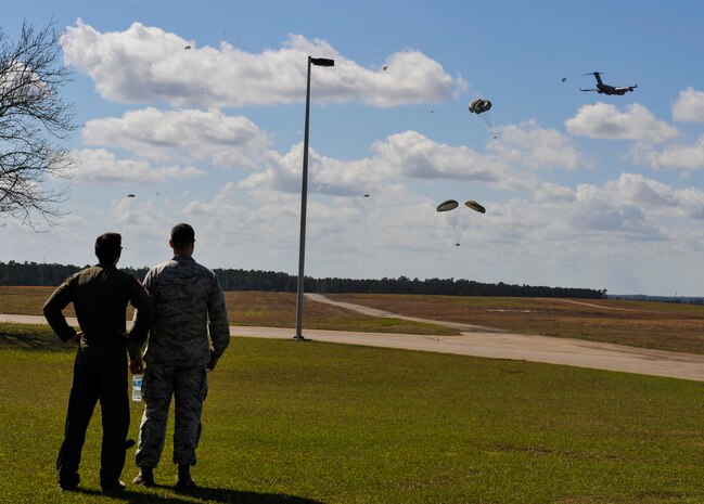Capt. Alex Hutcheson, left, 15th Airlift Squadron mission director, watches a high-velocity airdrop Feb. 24, 2018, at North Auxiliary Airfield, S.C.