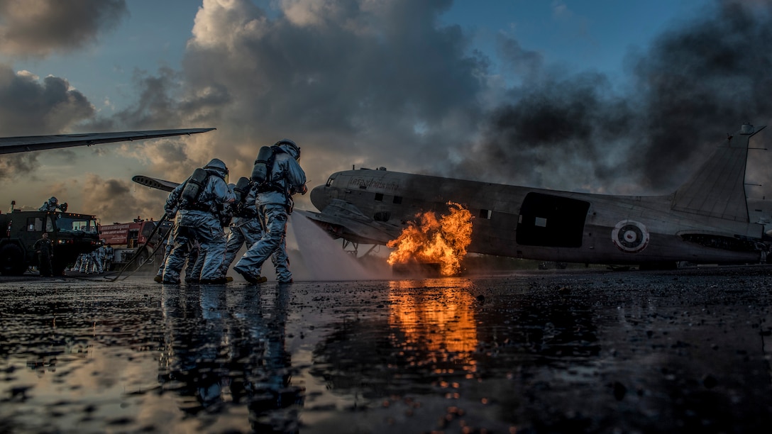Marine Corps firefighters from Marine Wing Support Squadron 172 and Royal Thai Navy firefighters work together to extinguish an aircraft fire simulating a crash during aircraft extraction training at U-Tapao International Airport, Ban Chang district, Rayong province, Thailand.