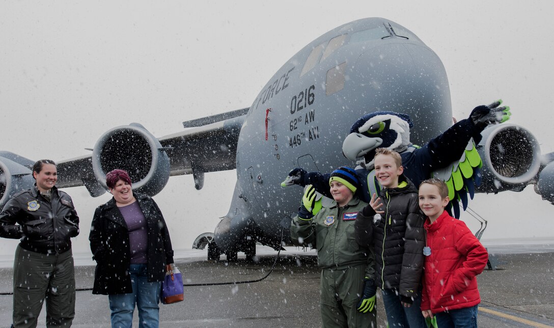 McKay Neel (third from left), McChord’s newest Pilot for a Day participant, and two friends take a photo with Blitz, Seattle Seahawks mascot, during a tour of McChord Field at Joint Base Lewis-McChord, Wash., Feb. 20, 2018. McKay was joined on his tour by his parents, two friends, their dad and 4th Airlift Squadron personnel. (U.S. Air Force photo by Senior Airman Tryphena Mayhugh)