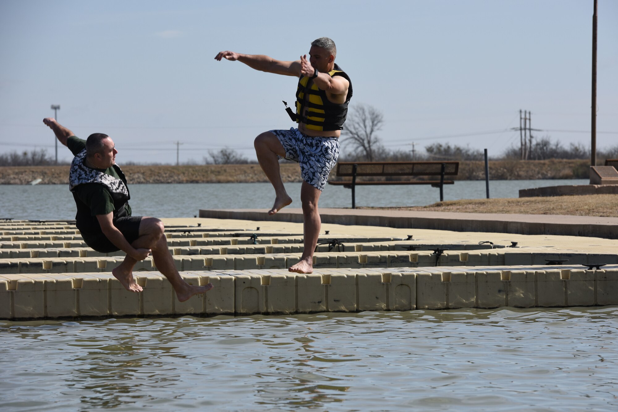 U.S. Air Force Chief Master Sgt. Daniel Stein, 17th Training Group superintendent, and Col. Alex Ganster, 17th TRG commander, represent the 17th TRG during the Polar Bear Plunge event hosted by the 17th Force Support Squadron at Lake Nasworthy in San Angelo, Texas, Feb. 24, 2018. After taking the plunge, service members could warm up by a fire while roasting s’mores. (U.S. Air Force photo by Airman 1st Class Seraiah Hines/Released
