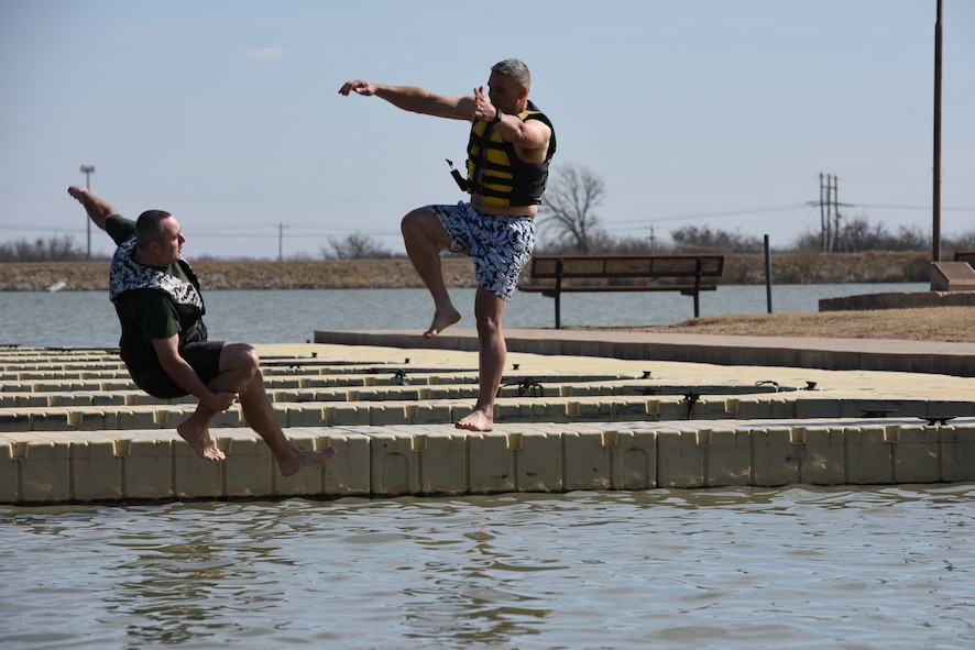 U.S. Air Force Chief Master Sgt. Daniel Stein, 17th Training Group superintendent, and Col. Alex Ganster, 17th TRG commander, represent the 17th TRG during the Polar Bear Plunge event hosted by the 17th Force Support Squadron at Lake Nasworthy in San Angelo, Texas, Feb. 24, 2018. After taking the plunge, service members could warm up by a fire while roasting s’mores. (U.S. Air Force photo by Airman 1st Class Seraiah Hines/Released