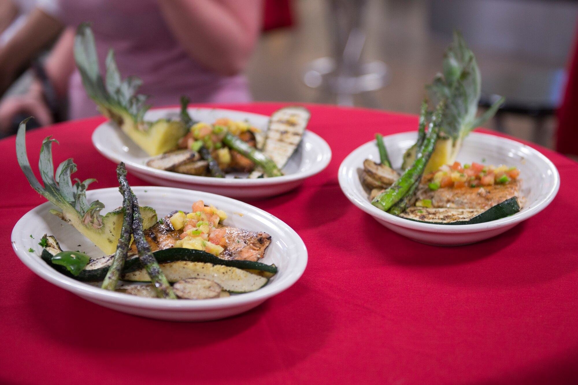 The winning meal of the 2018 Grill Masters competition - wood-fired grilled salmon with pineapple salsa, asparagus and vegetables – sits on display prior to judging at Luke Air Force Base, Ariz., Feb. 23, 2018. Each team was required to incorporate a secret ingredient, in this case pineapple, into a meal consisting of one meat and two sides. (U.S. Air Force photo/Senior Airman Ridge Shan)