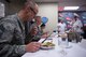 From front to back: Chief Master Sgt. Todd Kirsch, 56th Mission Support Group command chief, Col. Robert Sylvester, 56th Mission Support Group commander, and Maj. Maritzel Castrellon, 56th Force Support Squadron commander, judge a prepared dish during the 2018 Grill Masters competition while the chefs, Drake Montoya and Patrick Campbell, Airman and Family Readiness Center employees, look on nervously at Luke Air Force Base, Ariz., Feb. 23, 2018. Montoya and Campbell placed third.