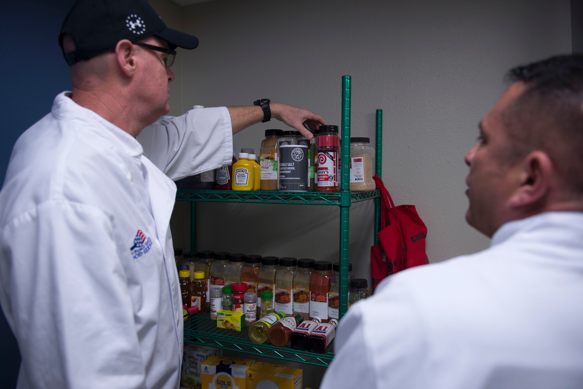 Patrick Campbell and Drake Montoya, forming a two-man team from the Airman and Family Readiness Center, searches through seasonings during the 2018 Grill Master competition at Luke Air Force Base, Ariz., Feb. 23, 2018. The competition challenged Airmen to craft a meal for judging from a slew of fresh produce, meat, and a unique secret ingredient. (U.S. Air Force photo/Senior Airman Ridge Shan)