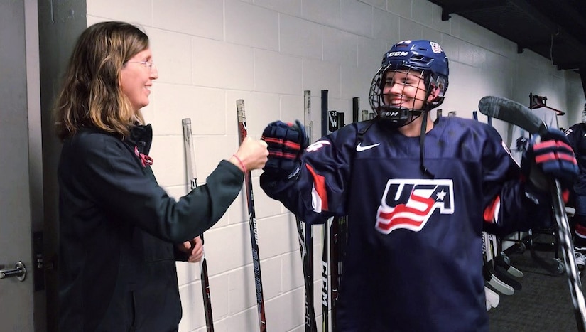Team doctor fist bumps Team USA Women's hockey player.