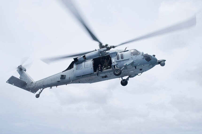 Naval Air Crewmen assigned to the “Island Knights” of Helicopter Sea Combat Squadron (HSC) 25 fly in an MH-60S Sea Hawk helicopter during a joint search and rescue exercise with Coastal Riverine Squadron 4, Det. Guam and U.S. Coast Guard Sector Guam, Feb. 23.