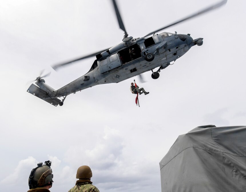 Naval Air Crewman (Helicopter) 2nd Class Spencer Kachele, assigned to the “Island Knights” of Helicopter Sea Combat Squadron (HSC) 25, is lowered by an MH-60S Sea Hawk helicopter to a Mark VI patrol boat manned by Coastal Riverine Squadron 4, Det. Guam, during a joint search and rescue exercise with U.S. Coast Guard Sector Guam, Feb. 23, 2018.