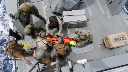 Coastal Riverine Squadron (CRS) 4, Det. Guam and Helicopter Sea Combat Squadron (HSC) 25 Sailors load a search and rescue (SAR) dummy onto a litter aboard a Mark VI patrol boat during a joint SAR exercise with U.S. Coast Guard Sector Guam, Feb. 23, 2018.