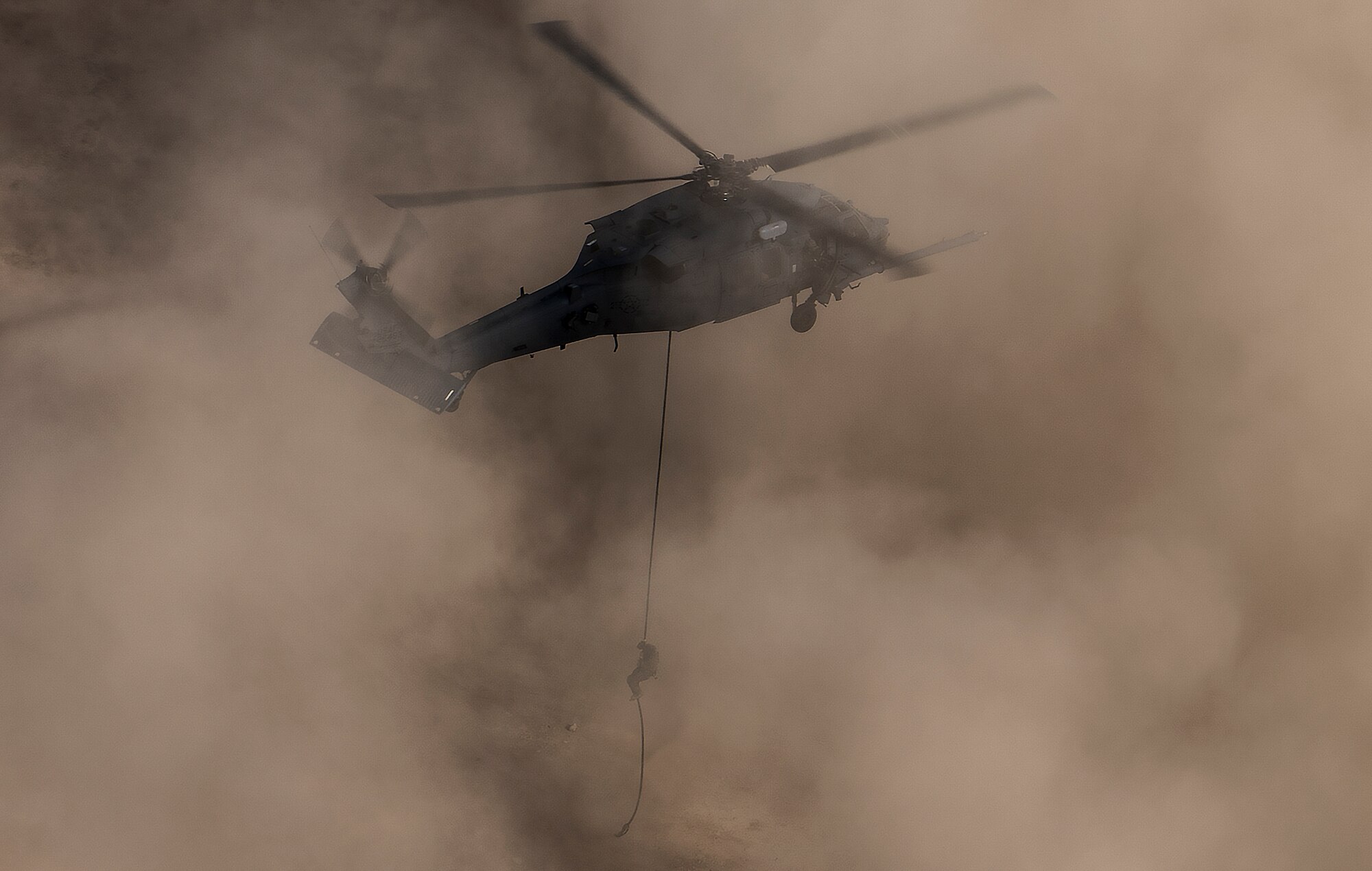 A pararescueman repels out of an HH-60G Pave Hawk helicopter, assigned to the 66th Rescue Squadron, during training on Nellis Air Force Base, Nevada, Feb. 22, 2018. Pararescuemen are highly trained experts who perform rescues in every type of terrain and partake in every part of the mission. From search and rescue and combat support to providing emergency medical treatment, parerescuemen ensure every mission is a successful one. (U.S. Air Force photo by Senior Airman Kevin Tanenbaum)