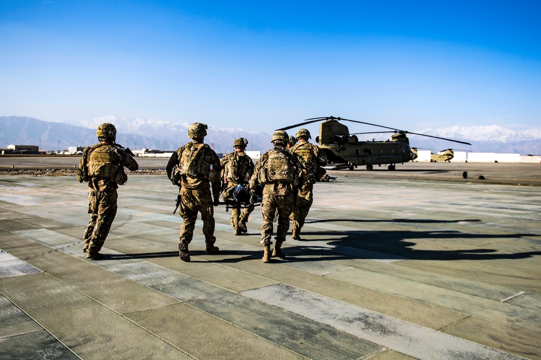 Soldiers carry a simulated casualty on a litter to an awaiting CH-47 Chinook helicopter.