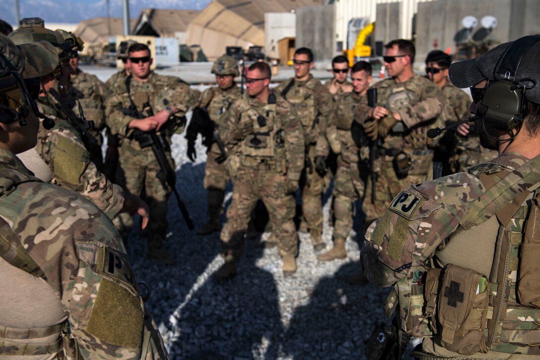 Air Force pararescuemen brief soldiers during integration and medical training on the flightline.