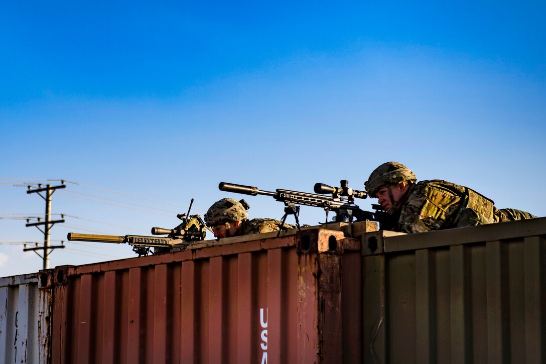 Soldiers provide perimeter security from a top of containers during a training exercise.