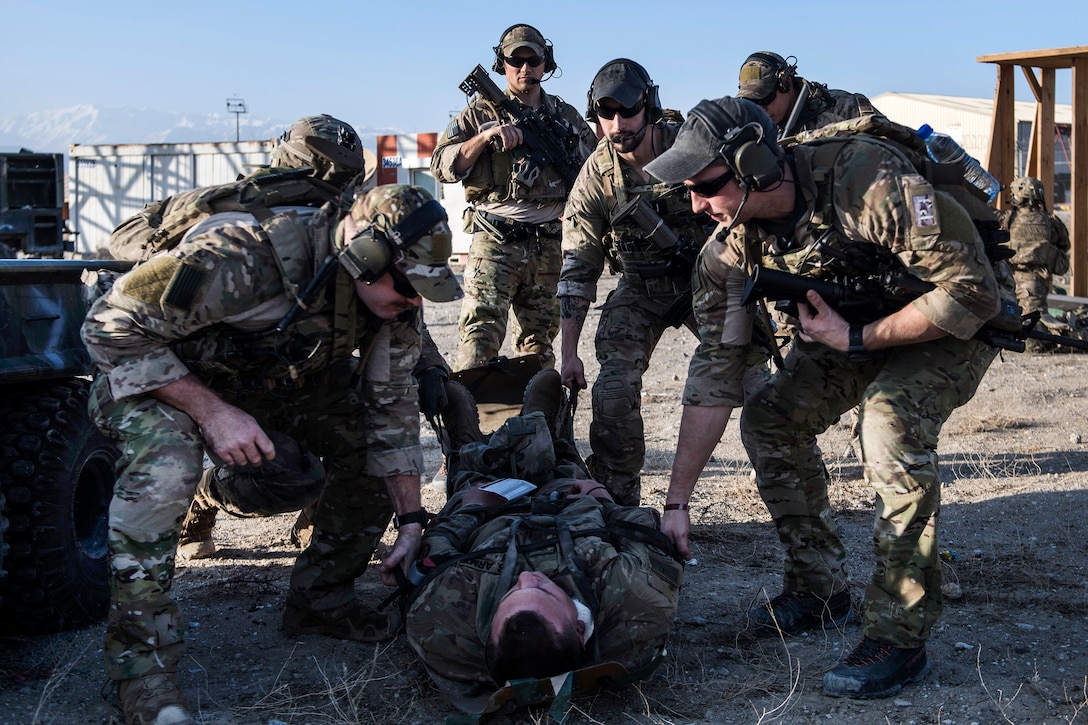 Air Force pararescuemen and soldiers prepare to transport a simulated casualty on a litter while conducting medical training during an exercise.