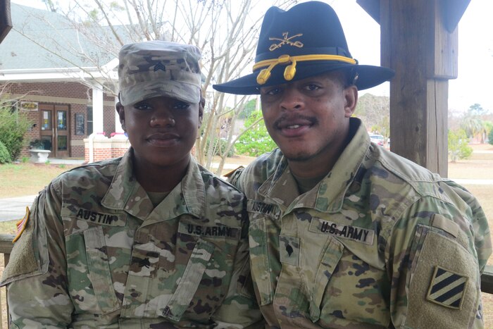 A male and female soldier pose for a picture.