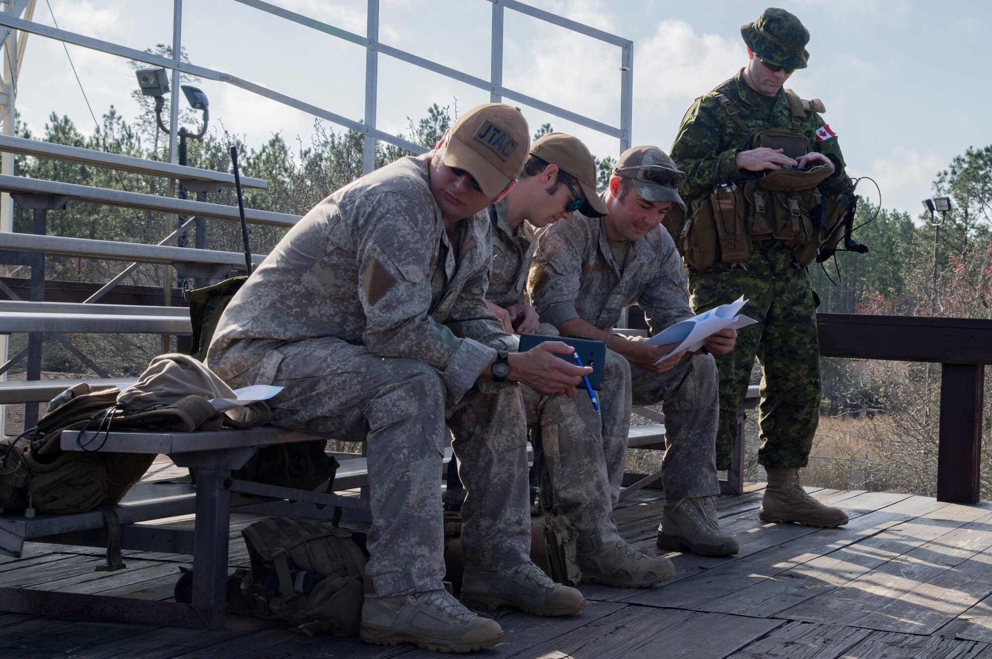 A group of Canadian Royal Air Force and New Zealand army joint terminal attack controllers discuss mission planning prior to combined training, Feb. 21, 2018, at Moody Air Force Base, Ga. Ally forces from the CRAF and NZA traveled to Moody AFB to train with the 75th Fighter Squadron on close air support. (U.S. Air Force photo by Staff Sgt. Eric Summers Jr.)