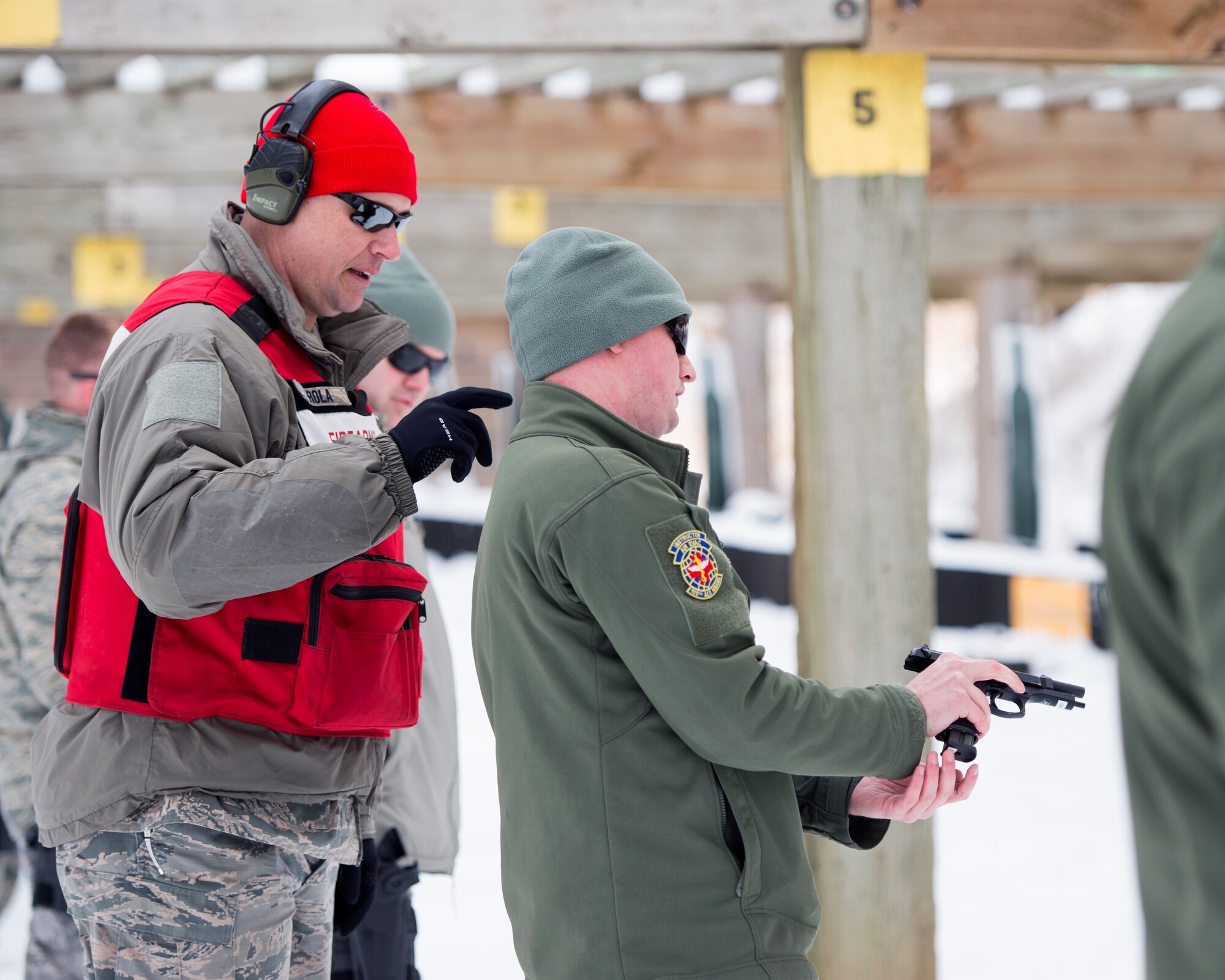 U.S. Air Force Tech. Sgt. Brian Erola, left, a combat arms training and maintenance instructor with the 133rd Security Forces Squadron, observes an Airman loading a M9 Beretta pistol in Coon Rapids, Minn., Feb. 23, 2018.