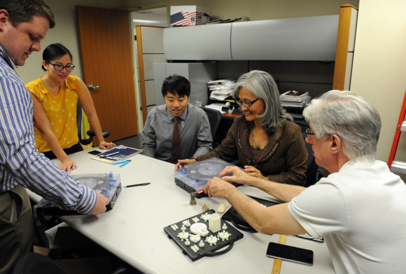 Samuel Pratt (left), an engineer with the Additive Manufacturing Project Office at Naval Surface Warfare Center, Carderock Division, teaches Office of Naval Research program managers (from left after Pratt) Dr. Jennifer Wolk, Stephen Glotzhober, Dr. Airan Perez and Dr. David Drumheller how to use a recently installed 3-D printer Oct. 19, 2017, in Arlington, Virginia.