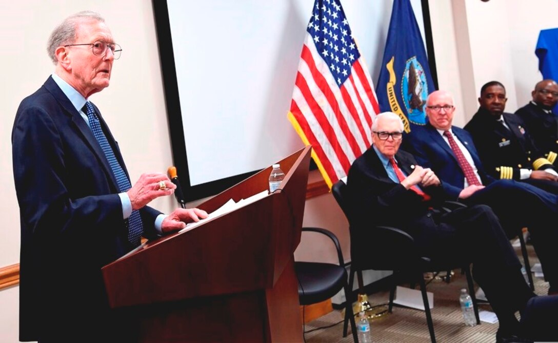 IMAGE: DAHLGREN, Va. (Feb. 22, 2018) – Retired Adm. James Hogg addresses the audience during the electromagnetic railgun line naming ceremony at Naval Surface Warfare Center Dahlgren Division, where he, along with Dr. Hans Mark, were honored. As public servants, Hogg and Mark laid the foundation for the U.S. Navy Railgun Program and led the effort to explore and illustrate to senior leadership the warfighting advantages of this game-changing technology and were pivotal in gaining the initial funding necessary to demonstrate its feasibility. (U.S. Navy photo by John F. Williams/Released)