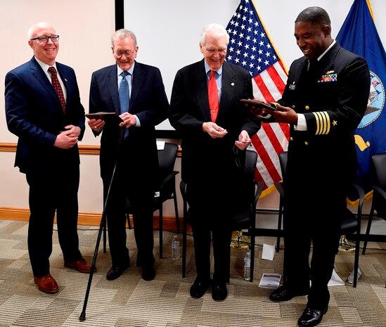 IMAGE: DAHLGREN, Va. (Feb. 22, 2018) – Capt. Godfrey 'Gus' Weekes, right, Naval Surface Warfare Center Dahlgren Division commanding officer, and Donald McCormack, left, executive director of the Naval Surface and Undersea Warfare Centers, present commemorative plaques to retired Adm. James Hogg, second from left, and Dr. Hans Mark, during an electromagnetic railgun line naming ceremony. As public servants, Hogg and Mark laid the foundation for the U.S. Navy Railgun Program and led the effort to explore and illustrate to senior leadership the warfighting advantages of this game-changing technology and were pivotal in gaining the initial funding necessary to demonstrate its feasibility. (U.S. Navy photo by John F. Williams/Released)