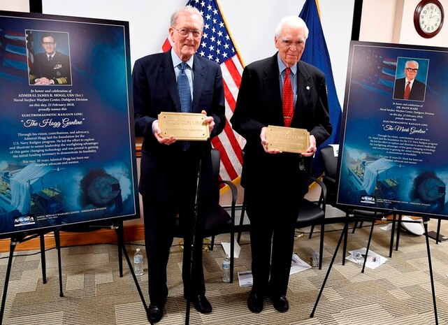 IMAGE: DAHLGREN, Va. (Feb. 22, 2018) – Retired Adm. James Hogg, left, and Dr. Hans Mark pose with the plaques that bear their names and will be installed on the electromagnetic railgun line at Naval Surface Warfare Center Dahlgren Division. As public servants, Hogg and Mark laid the foundation for the U.S. Navy Railgun Program and led the effort to explore and illustrate to senior leadership the warfighting advantages of this game-changing technology and were pivotal in gaining the initial funding necessary to demonstrate its feasibility. (U.S. Navy photo by John F. Williams/Released)